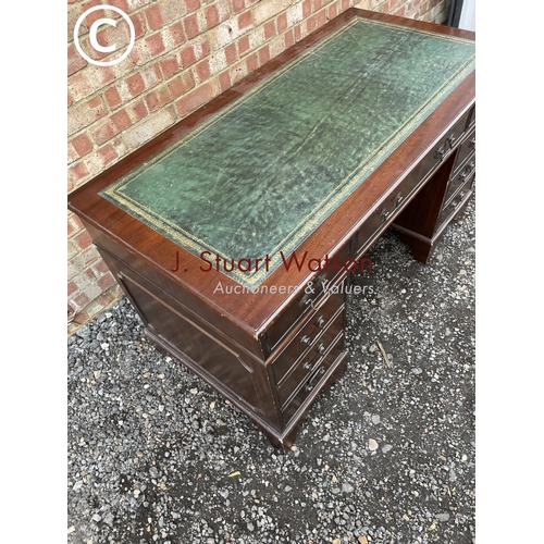 278 - A reproduction mahogany pedestal desk with a green leather top