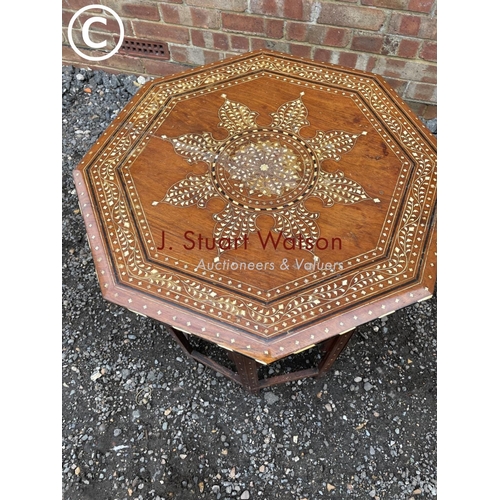 283 - An eastern style inlaid octagonal table on folding base