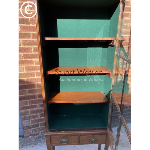 320 - A mahogany gun case, glazed top over two drawers, fitted with racking to the inside, also three late... 