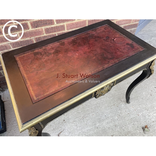 329 - An ebonised Victorian two drawer writing table with red leather top and brass mounts