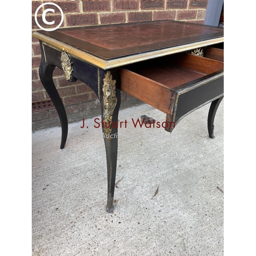 329 - An ebonised Victorian two drawer writing table with red leather top and brass mounts