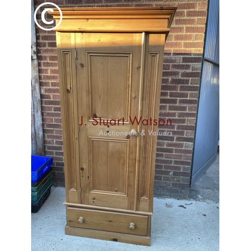 334 - A solid pine single door wardrobe on drawer base