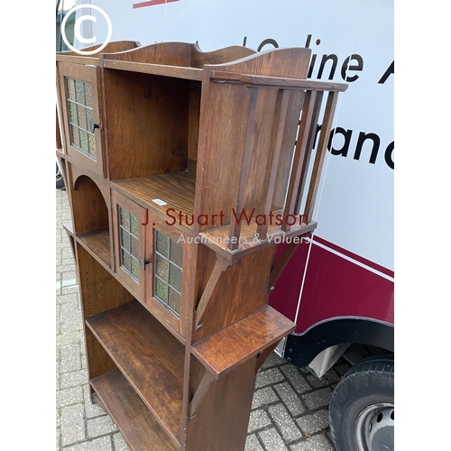 355 - A 20th century arts and crafts bookcase with leaded stained glass doors