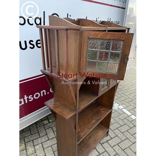 355 - A 20th century arts and crafts bookcase with leaded stained glass doors