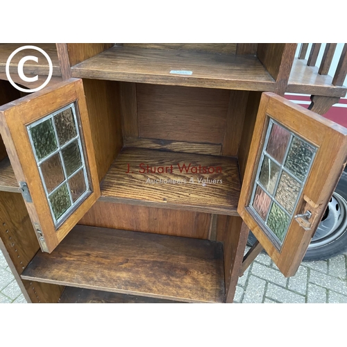 355 - A 20th century arts and crafts bookcase with leaded stained glass doors