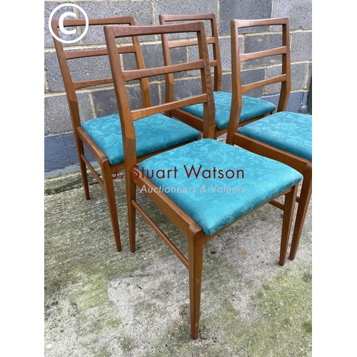 384 - A set of four mid century light oak dining chairs with blue upholstered drop in seats