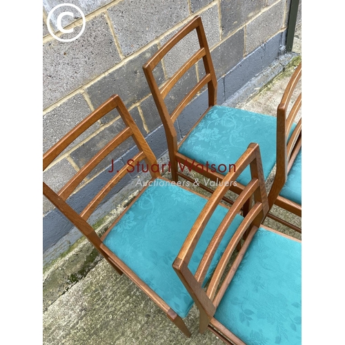 384 - A set of four mid century light oak dining chairs with blue upholstered drop in seats