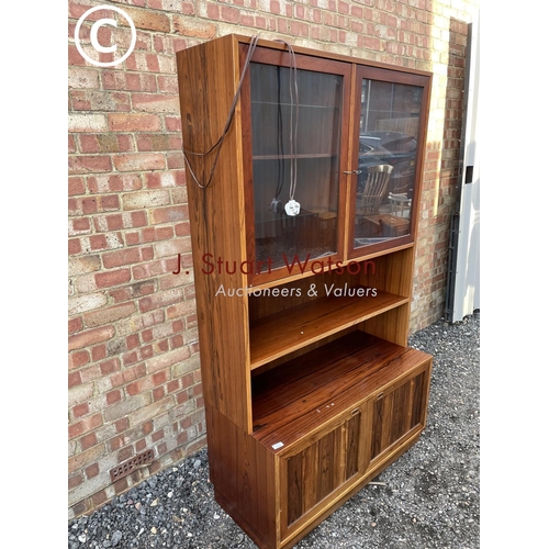 42 - A Danish rosewood bookcase cabinet with a glaze top over shelf and two cupboards