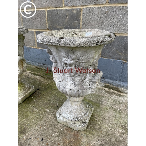 438 - A pair of decorative concrete garden urns 58cm high