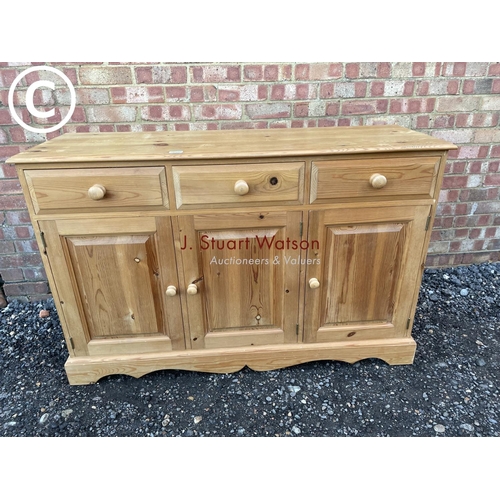 65 - A solid pine three drawer sideboard