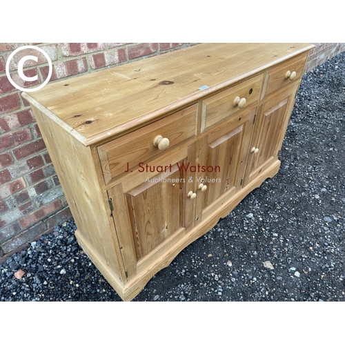 65 - A solid pine three drawer sideboard