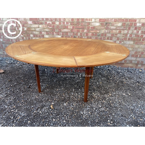 83 - A mid century teak extending  'Flip Flap' table by dyrlund with drawer leaf fold over extensions