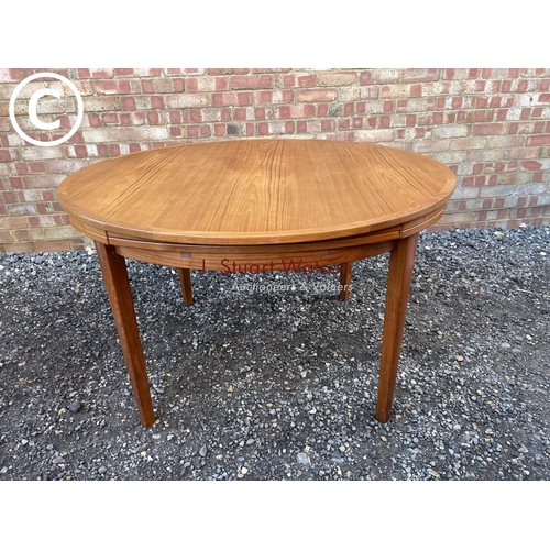 83 - A mid century teak extending  'Flip Flap' table by dyrlund with drawer leaf fold over extensions