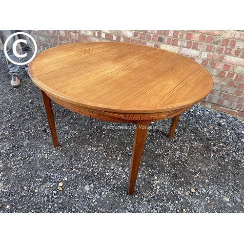 83 - A mid century teak extending  'Flip Flap' table by dyrlund with drawer leaf fold over extensions