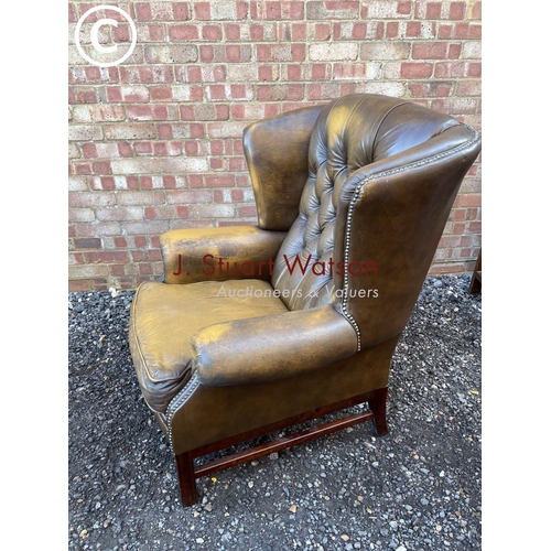 84 - A brown leather wing back Chesterfield armchair