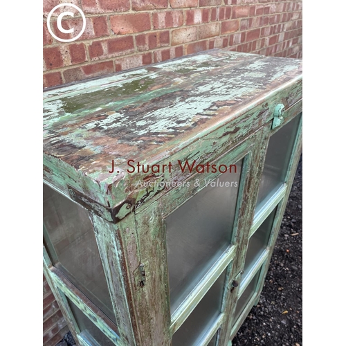 90 - A distressed green painted modern glazed cabinet with two internal shelves