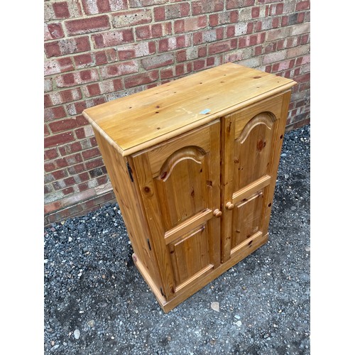 423 - A small solid pine two door cupboard