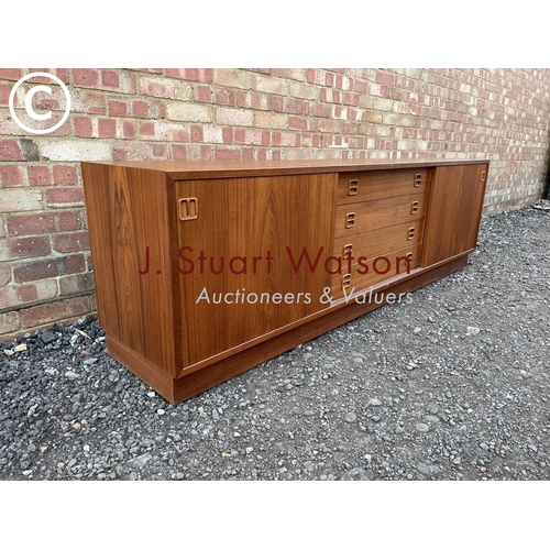 1 - A danish teak lowboy sideboard by Clausen & Son having four  central drawers flanked by sliding door... 