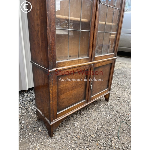 135 - An early 20th century oak bookcase with leaded glass doors