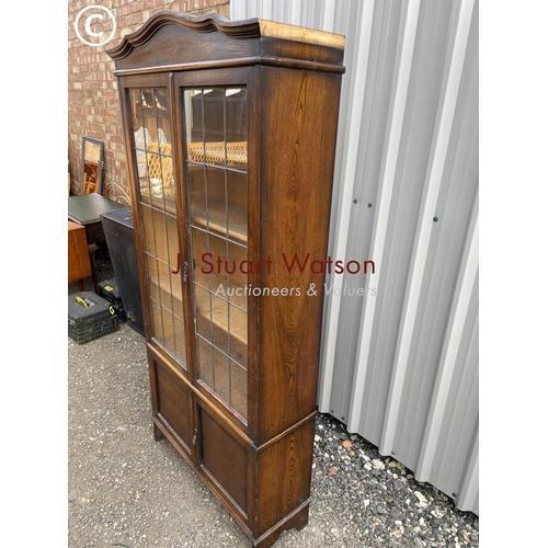 135 - An early 20th century oak bookcase with leaded glass doors