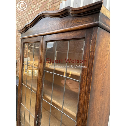 135 - An early 20th century oak bookcase with leaded glass doors