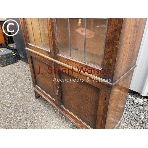 135 - An early 20th century oak bookcase with leaded glass doors