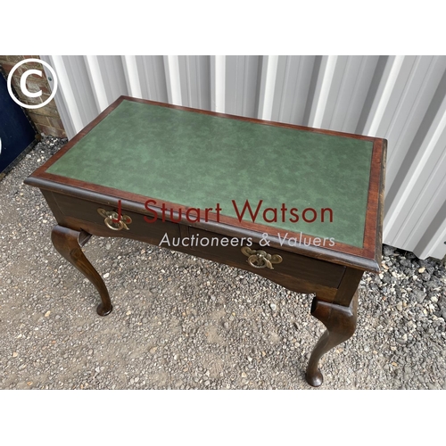 147 - A mahogany two drawer writing table with a green leather top