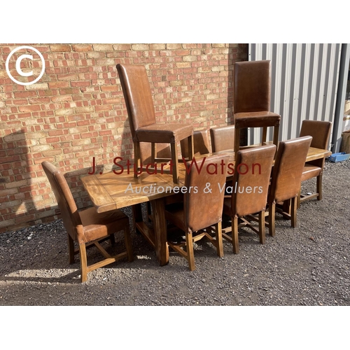 176 - A very large reproduction oak dining table together with a set of ten leather high back dining chair... 