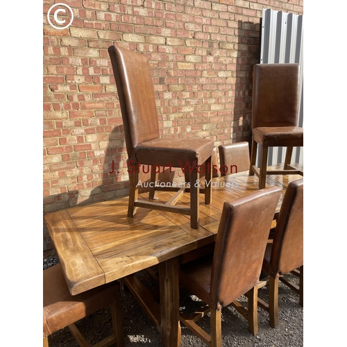 176 - A very large reproduction oak dining table together with a set of ten leather high back dining chair... 