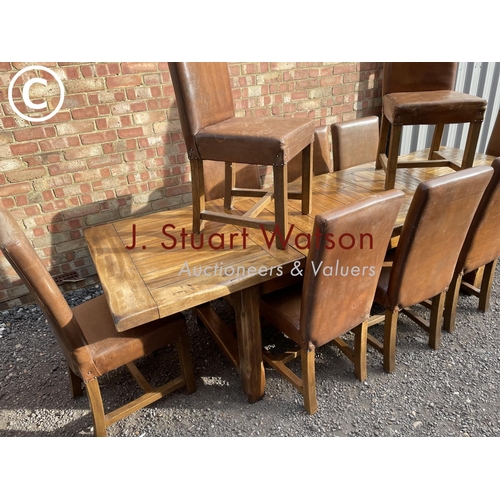 176 - A very large reproduction oak dining table together with a set of ten leather high back dining chair... 