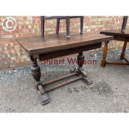 224 - Two early 20th century oak drawer leaf tables together with two chairs