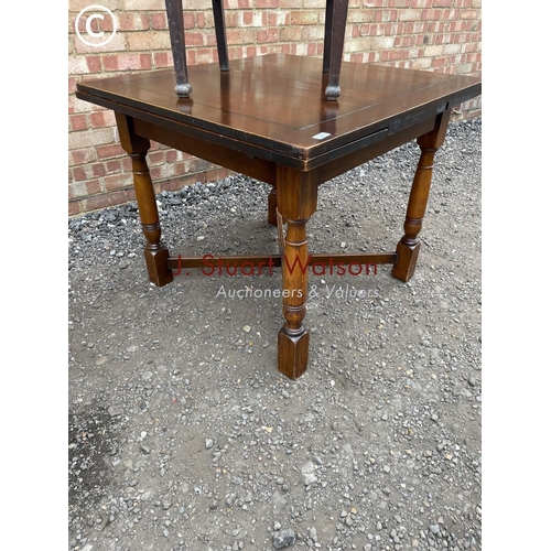 224 - Two early 20th century oak drawer leaf tables together with two chairs