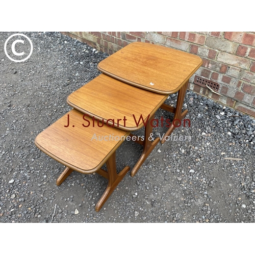 230 - A mid century teak nest of three tables