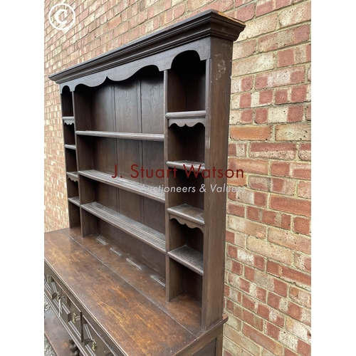 231 - An antique barley twist oak dresser with a plate rack back over three drawer base