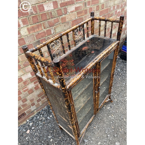 25 - An antique bamboo two door glazed cabinet