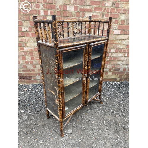 25 - An antique bamboo two door glazed cabinet