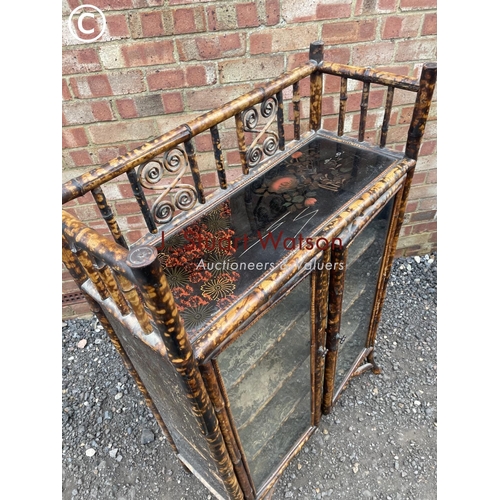 25 - An antique bamboo two door glazed cabinet