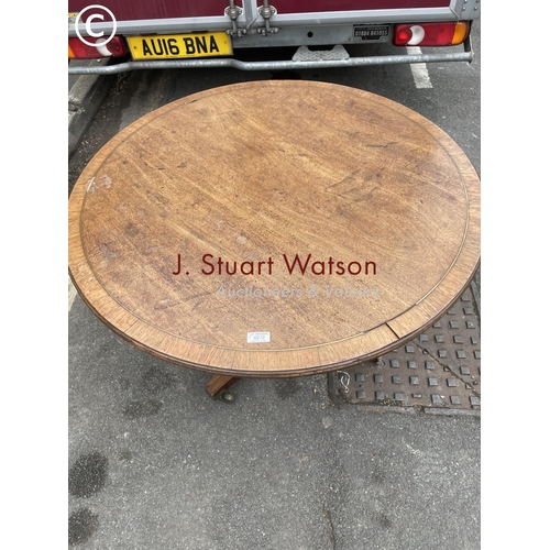 272 - A circular oak tilt top table with brass inlay