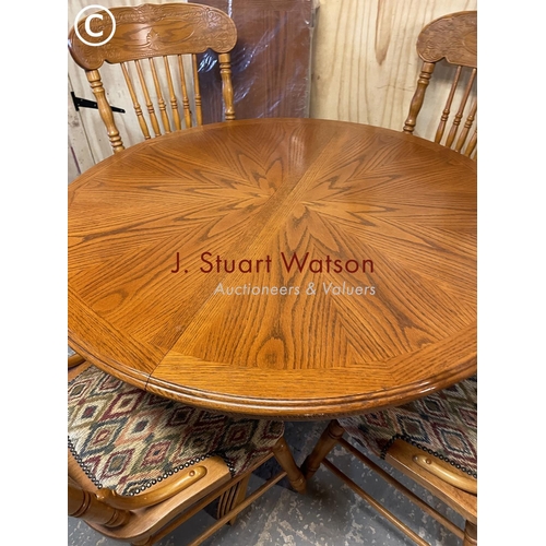 373 - A dutch style circular oak dining table with extension leaf and four chairs