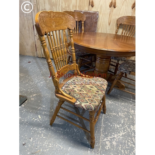 373 - A dutch style circular oak dining table with extension leaf and four chairs