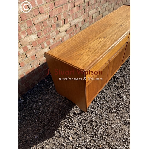 48 - A mid century teak sideboard with two drawers over four cupboard doors raised on hairpin legs