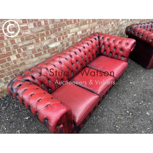 1 - An oxblood red leather chesterfield three seater sofa together with matching club style armchair