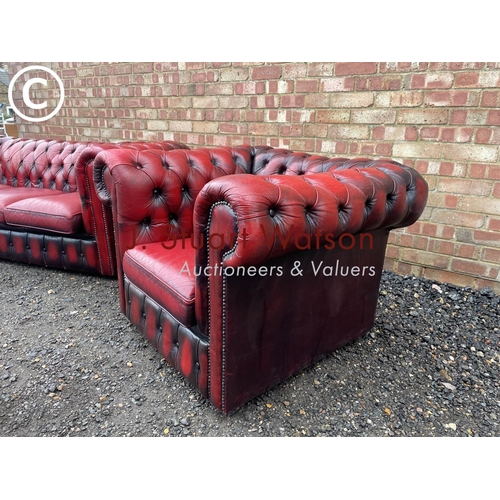 1 - An oxblood red leather chesterfield three seater sofa together with matching club style armchair