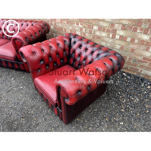 1 - An oxblood red leather chesterfield three seater sofa together with matching club style armchair