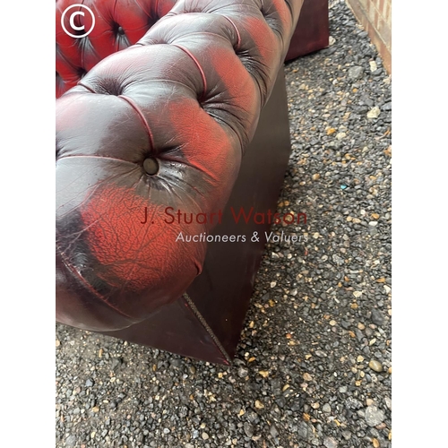 1 - An oxblood red leather chesterfield three seater sofa together with matching club style armchair