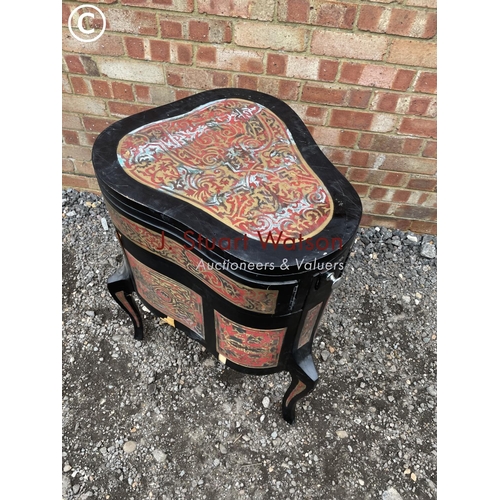 103 - An unusual black laquered vanity chest with fold over top to reveal mirror and leather surface