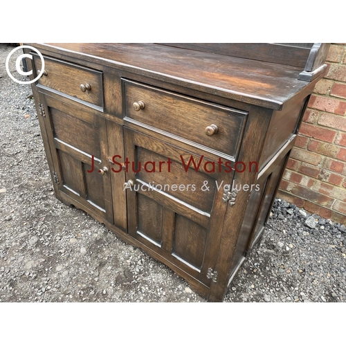 106 - A solid oak dresser with plate rack back over two drawers and cupboard base