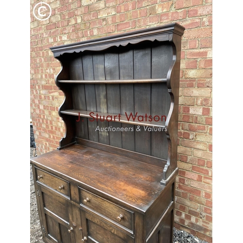 106 - A solid oak dresser with plate rack back over two drawers and cupboard base