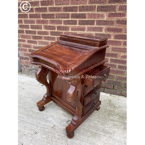 123 - A reproduction mahogany davenport with four drawers and a fitted interior