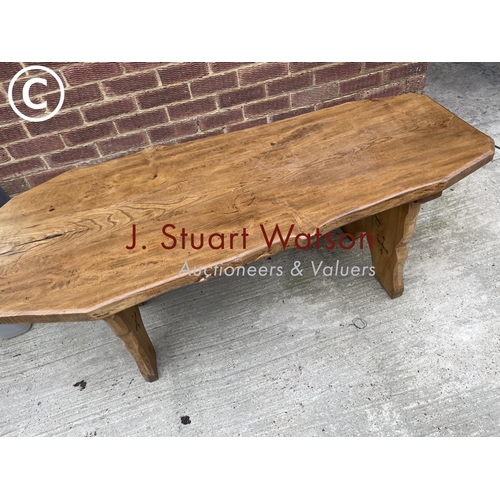 133 - An ecclesiastic style oak log effect table, carved to the base